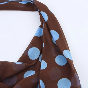 Detailed view of lightweight brown chiffon scarf featuring light blue polka dot pattern