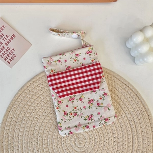 Close-up of floral canvas nurse pouch with checkered pocket and white snap buckle