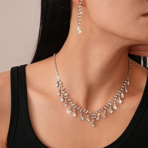 Close-up of elegant teardrop necklace and matching earrings set with sparkling stones