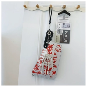 Detailed view of silver cleaver-shaped crossbody bag with red blood prints and bone handle