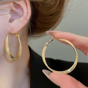 Detail of 18k gold plated double layered hoop earrings showing elegant twisted texture