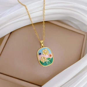 Elegant gold oval enamel floral pendant necklace with colorful gems on silk fabric