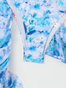 Detailed macro view of blue floral print swimsuit with ruffled edges and size S label