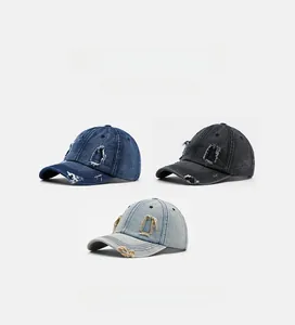 Detailed view of distressed denim baseball caps with artificial fraying and ripped holes
