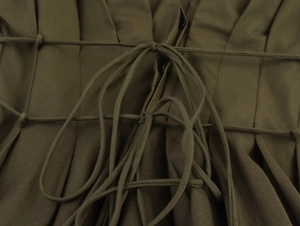 Gros plan d'une robe mi-longue plissée vert olive avec cordon de serrage à la taille