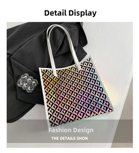 Detail view of holographic laser tote bag featuring heart geometric patterns and white handles