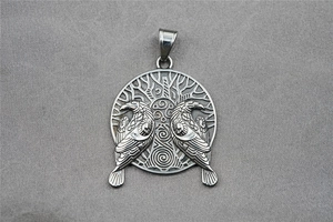 Macro shot of silver Viking pendant featuring twin ravens and Tree of Life motif