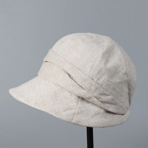 Détail de la texture en lin beige respirant et du ruban plissé sur le chapeau de soleil