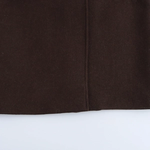 Detailed close-up of dark brown wool fabric texture and vertical seam stitching