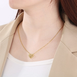 Gros plan du collier cœur plaqué or 18 carats avec gravure mama sur le cou du mannequin