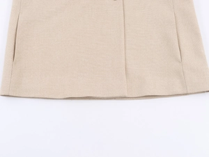 Detail of beige long sleeve blazer showing clean hem stitching and twill woven texture