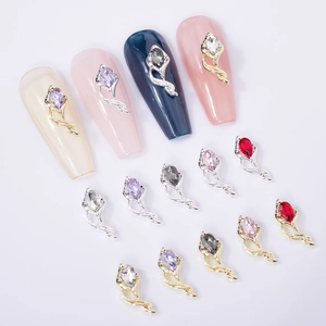 Macro view of teardrop nail charms with marquise crystals and flower-shaped metal bases
