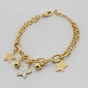 Détail d'un bracelet double couche en or 18K avec breloques étoiles en strass