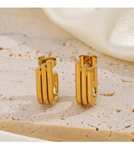Detailed view of gold plated triple layered irregular hoop earrings on stone and silk