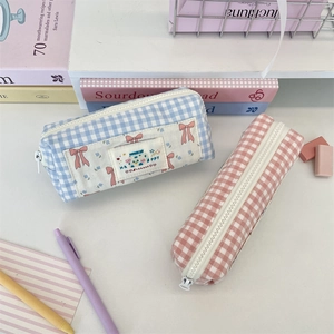 Blue and pink gingham canvas pencil cases with cute Happy patch on white desk