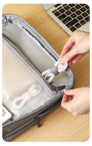 Detailed view of grey fabric cable organizer bag with internal mesh compartments
