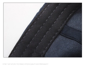 Macro shot of reinforced triple stitching on a washed navy cotton baseball cap brim
