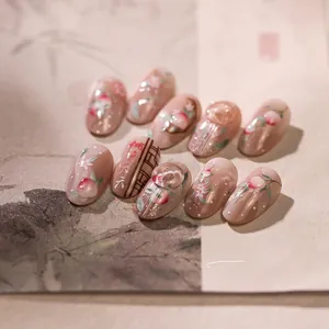 Macro detail of almond peach-themed press-on nails with 3D water droplets and calligraphy