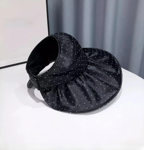 Detail of black sun hat with pleated wave brim and sparkling rhinestone accents