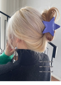 Detail view of a purple star-shaped hair claw clip used for a Korean style updo