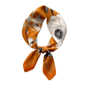 Elegant ginger floral silk scarf tied in a knot, featuring gray and white flower prints
