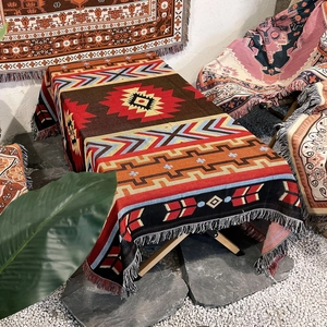 Detailed close-up of bohemian geometric woven blanket with fringe and tribal patterns