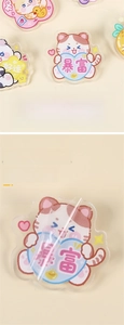 Detail of 4cm acrylic cartoon cat badge showing the removable clear protective film layer