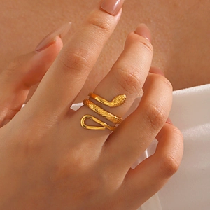 Minimalist gold snake ring with realistic scale texture worn by a fashion model