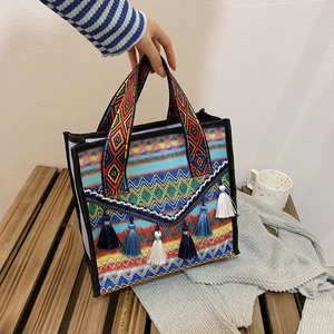 Ethnic bohemian woven tote bag with colorful geometric patterns and blue fringe tassels