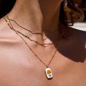 Collier 3 rangs en acier doré 18K avec pendentif arbre de vie porté par un mannequin