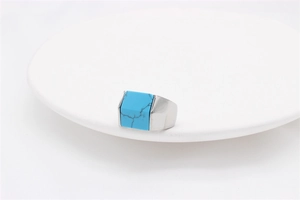 Macro detail of men's square blue turquoise stone set in a polished silver steel band