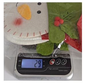 Detailed view of Christmas felt gift bag weighing 29g on a digital scale for shipping