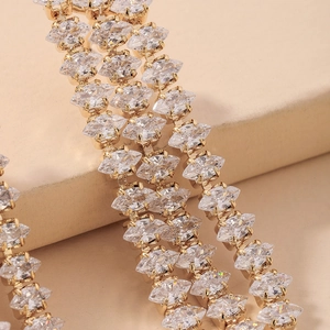 Macro shot of marquise-cut crystals in gold-plated settings on luxury tassel earrings