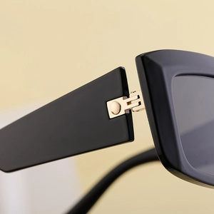 Detail of premium gold metal hinge on black cat-eye sunglasses with polished finish