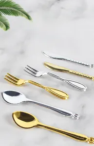Miniature dollhouse cutlery set featuring gold and silver toy knives forks and spoons