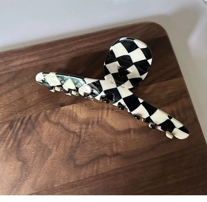 Detail of checkered black and white acetate hair claw clip with Barrette La France text