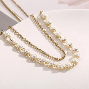 Elegant double-layer gold chain necklace featuring multiple white heart-shaped pearl charms