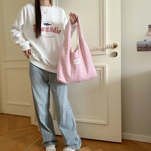Detailaufnahme der rosa karierten Tragetasche mit buntem Buchstabenetikett für Alltag