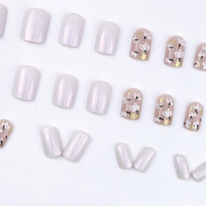 Short square press-on nails with pearl luster, pink base, white flowers and gold foil accents