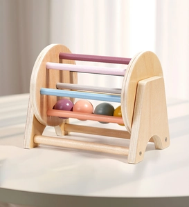 Close-up of a wooden Montessori spinning drum with colorful wooden balls and smooth finish