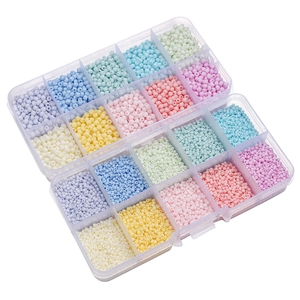 Macro detail of assorted pastel glass seed beads in two transparent plastic storage box