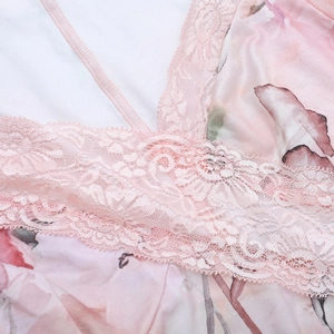 Close-up of floral print fabric with intricate pink lace trim on a slim fit dress