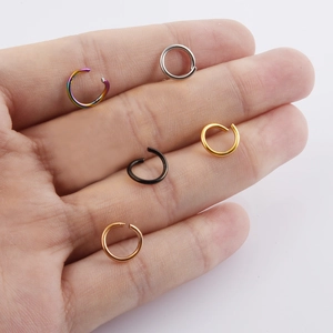 Five assorted colors of 4mm-10mm jump rings for DIY jewelry making on a palm