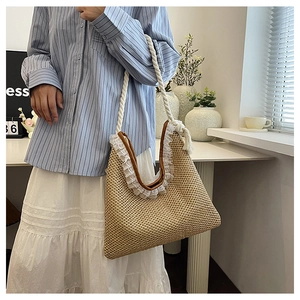 Detail of woven straw handbag with brown leather trim, lace edge, and rope handle straps
