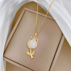 Elegant gold tulip necklace with white inlay on silk background in a jewelry box