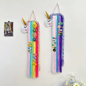 Détail d'un support barrettes licorne en feutrine avec longs glands en fil arc-en-ciel