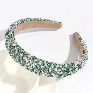 Detail of green rhinestones and white pearls on headband with khaki velvet lining