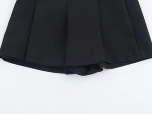 Détail de la jupe-culotte plissée noire montrant la texture du tissu tissé de qualité