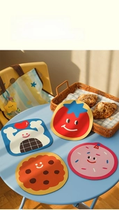 Détail de quatre dessous de verre en boue de diatomée aux formes de tomate et de donut