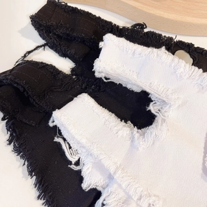 Detailaufnahme von Distressed-Denim mit offenen Kanten und zerrissener Textur